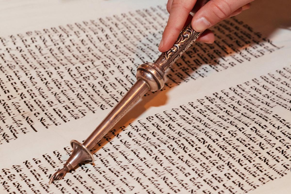 Reading from a Torah scroll with a silver yad